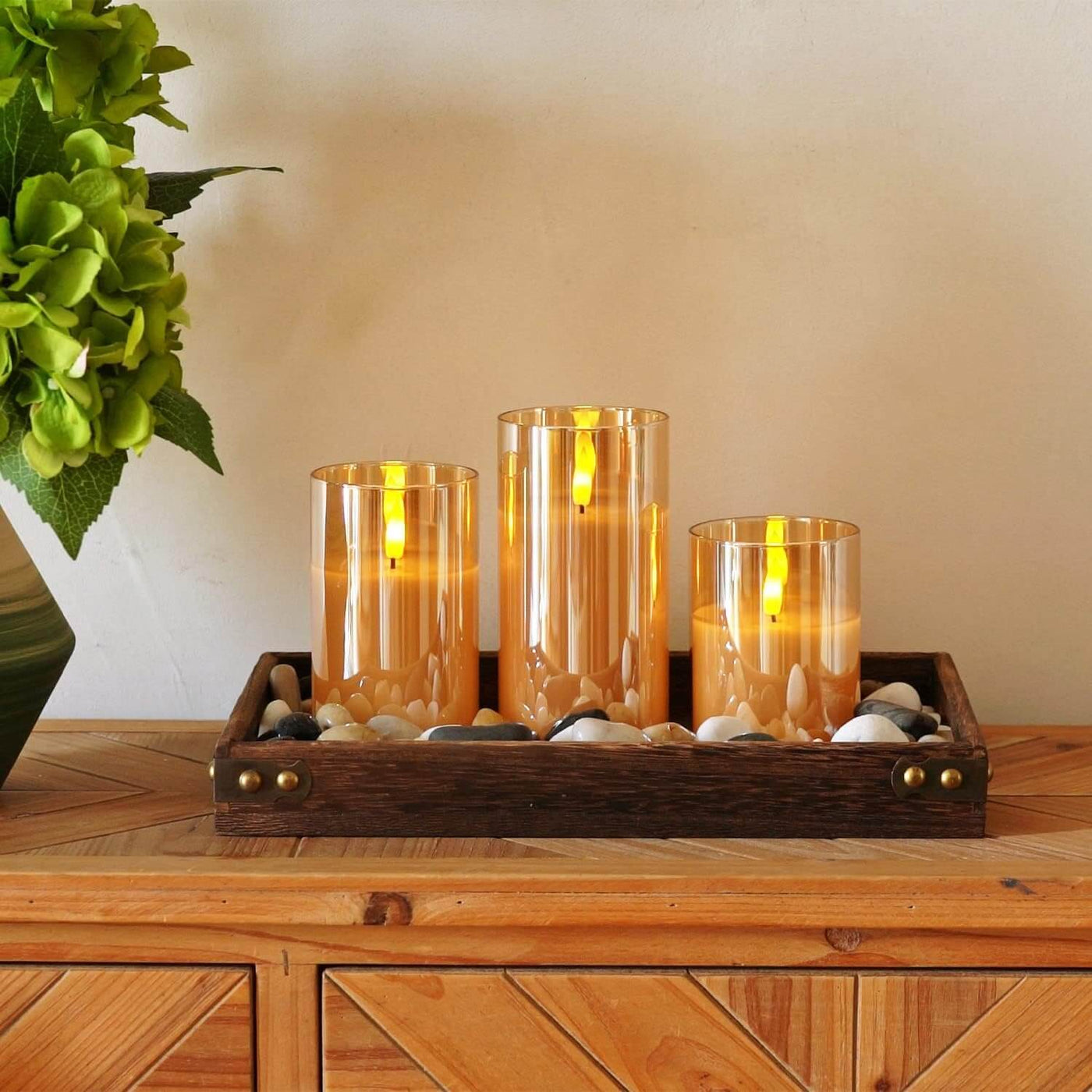 Remote control setting a timer on a set of three flameless candles