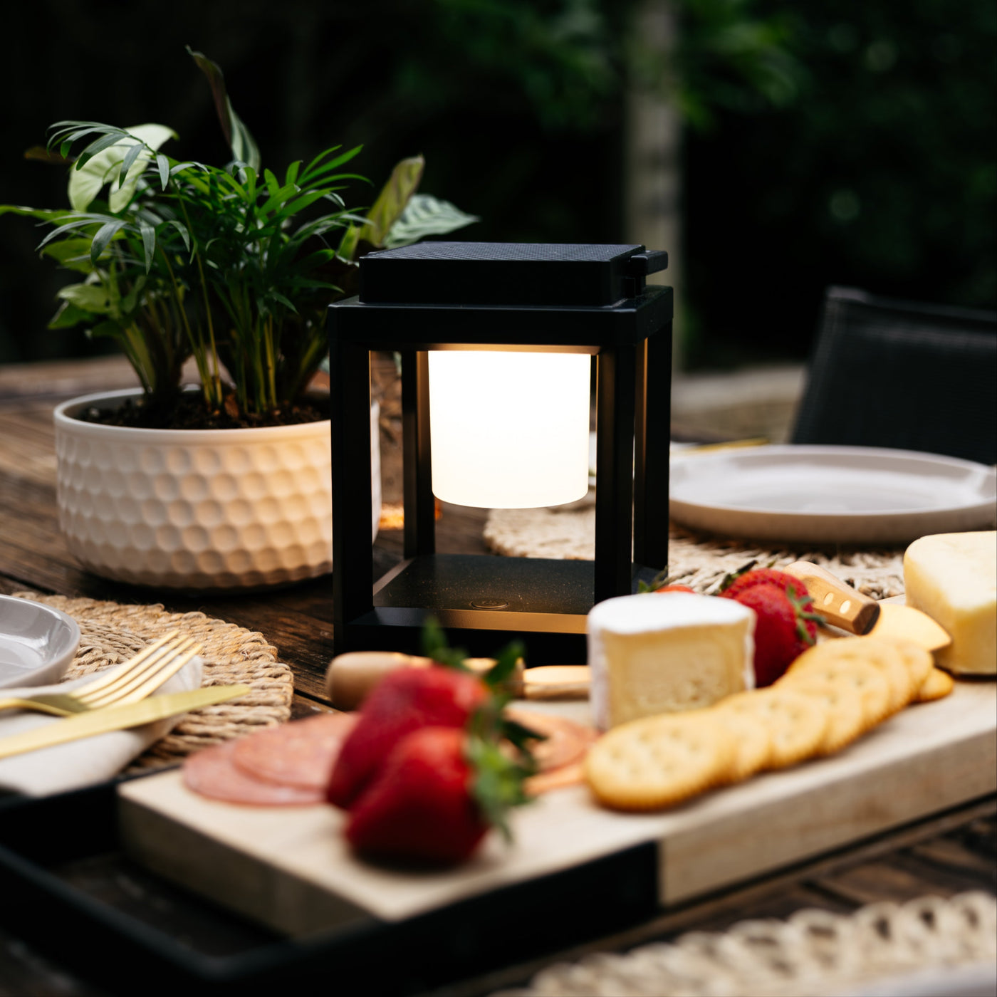 Solar lantern being carried from a dining table to a deck rail