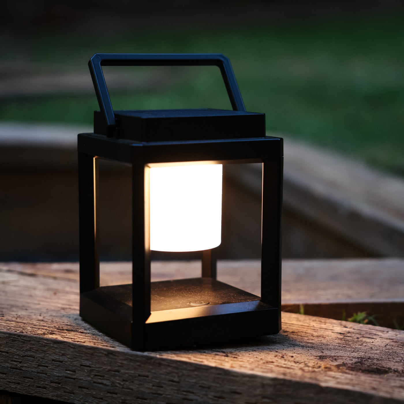 Group seated around an outdoor table lit by a warm solar lantern