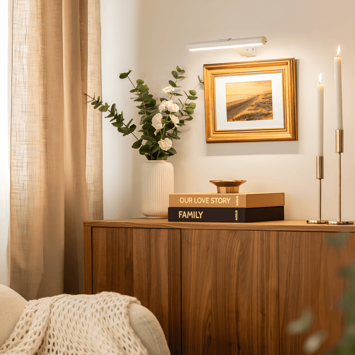 Rechargeable bedroom wall light highlighting artwork above a bed