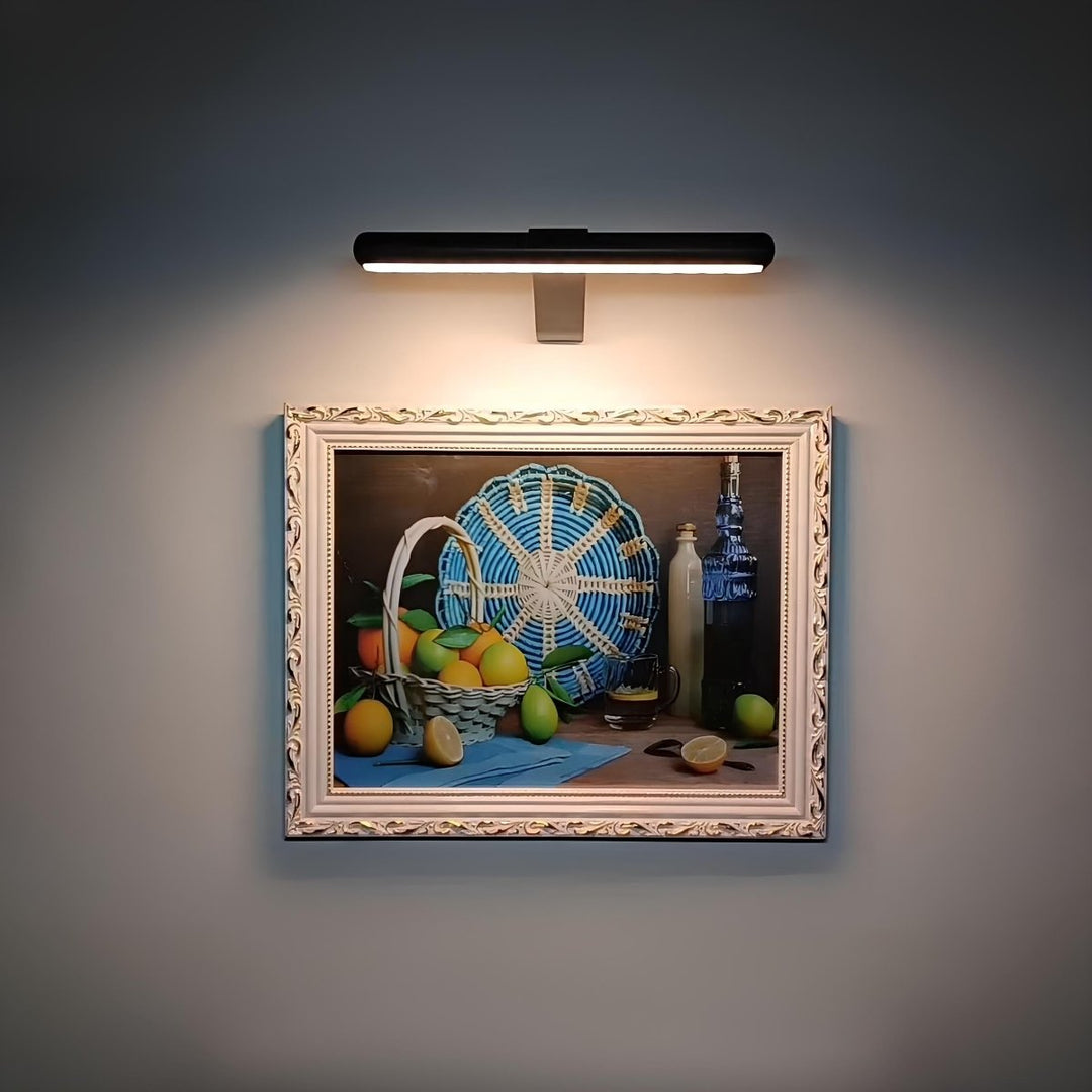 LumiFrame™ picture wall light illuminating framed artwork in a living room