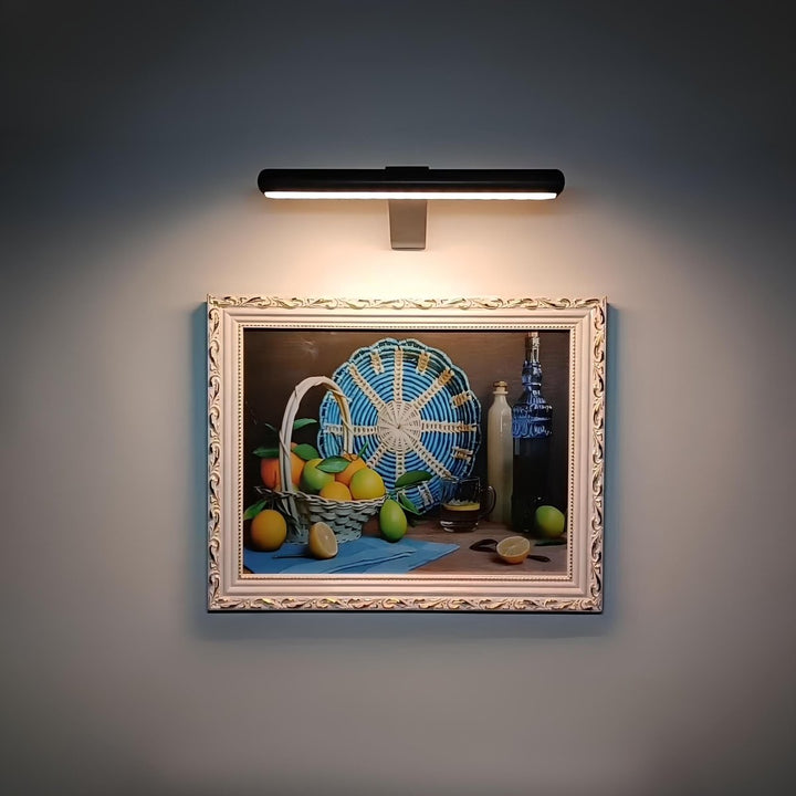 LumiFrame™ picture wall light illuminating framed artwork in a living room